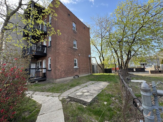 913 Wethersfield Ave, Hartford, CT 06114 - back of house with brick siding, a balcony, and fence