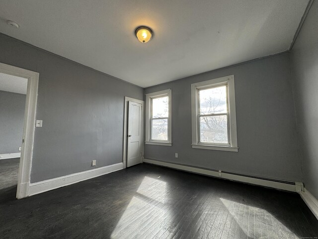 913 Wethersfield Ave, Hartford, CT 06114 - empty room with baseboard heating, dark wood-style flooring, baseboards, and a smoke detector