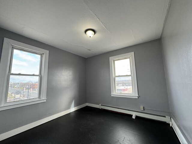 913 Wethersfield Ave, Hartford, CT 06114 - unfurnished room featuring baseboard heating, baseboards, and dark wood-style flooring