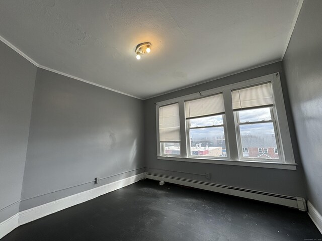 913 Wethersfield Ave, Hartford, CT 06114 - spare room featuring concrete flooring, baseboards, crown molding, baseboard heating, and a textured ceiling