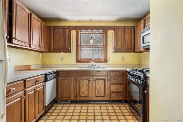kitchen with a sink, stainless steel dishwasher, light countertops, gas stove, and light floors