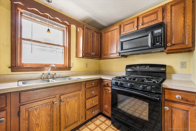 kitchen featuring black appliances, brown cabinets, and a sink