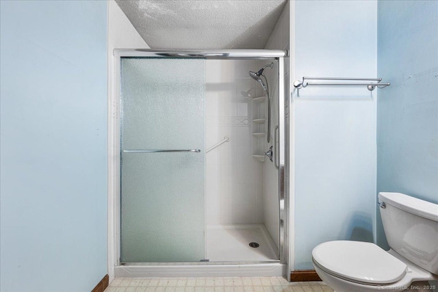 full bathroom featuring tile patterned floors, a textured ceiling, toilet, and a stall shower