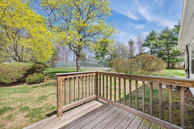 wooden deck featuring a lawn and fence