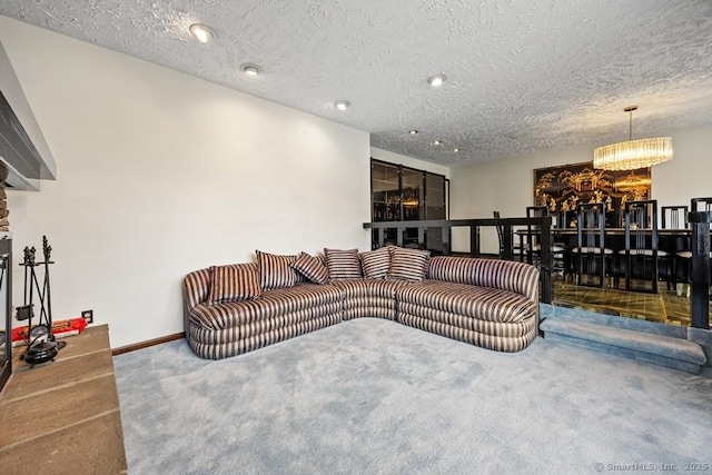 carpeted living area featuring recessed lighting, a textured ceiling, baseboards, and a notable chandelier