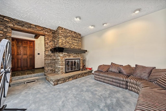 living area featuring a fireplace, carpet, and a textured ceiling