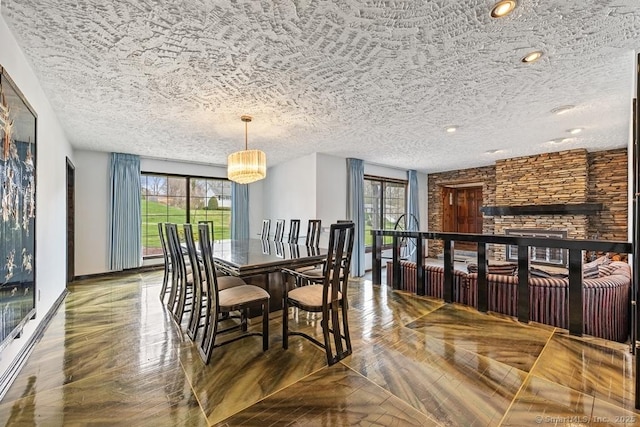 dining room featuring a fireplace, a textured ceiling, and a notable chandelier