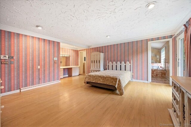 bedroom with a textured ceiling, baseboards, wallpapered walls, wood finished floors, and ornamental molding