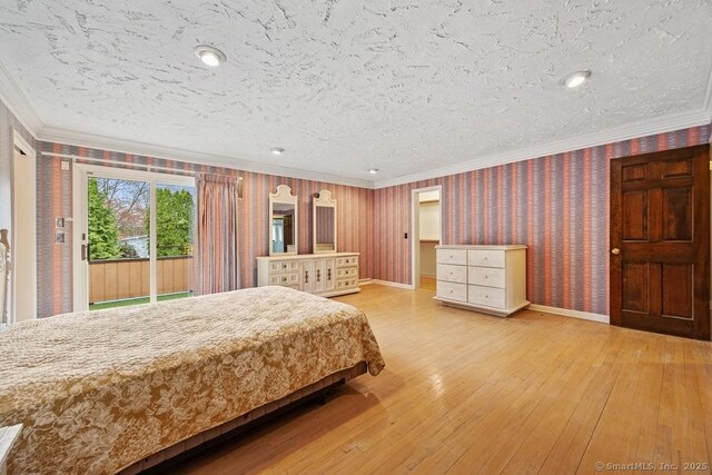 bedroom featuring wallpapered walls, ornamental molding, a textured ceiling, hardwood / wood-style flooring, and access to outside