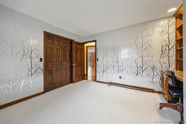 unfurnished office featuring carpet floors and baseboards