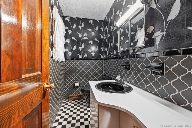 bathroom featuring tile walls, vanity, and wainscoting