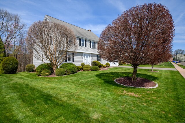view of property exterior featuring a chimney and a lawn