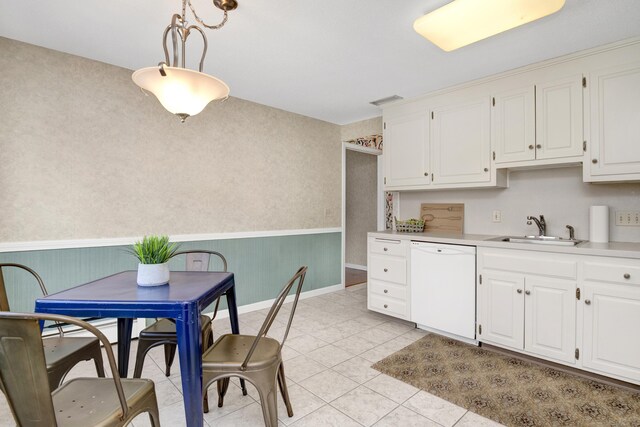 kitchen featuring white cabinetry, light countertops, white dishwasher, and a sink