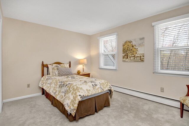bedroom with baseboards, light carpet, and a baseboard heating unit