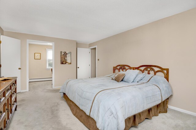bedroom with a baseboard heating unit, light carpet, and baseboards