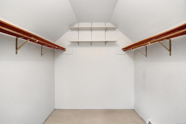 walk in closet featuring lofted ceiling and light carpet