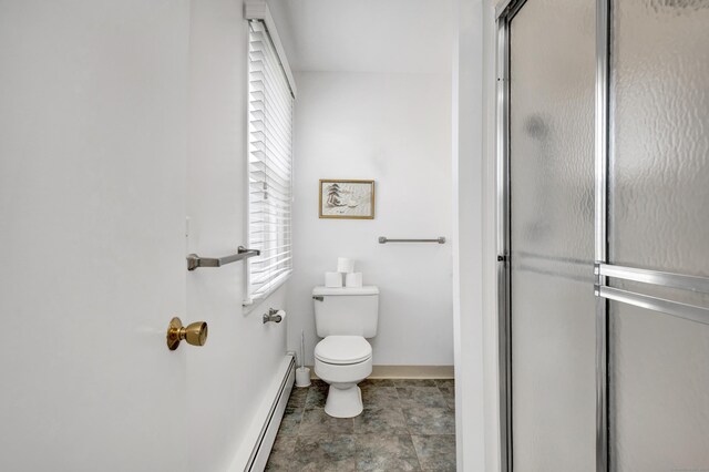 bathroom with toilet, a baseboard heating unit, a shower with shower door, and baseboards