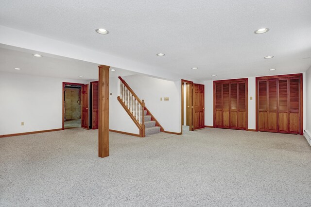 finished below grade area featuring stairway, light colored carpet, recessed lighting, and baseboards