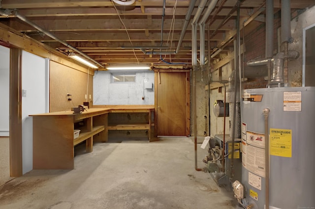 below grade area with gas water heater, a workshop area, and a baseboard radiator