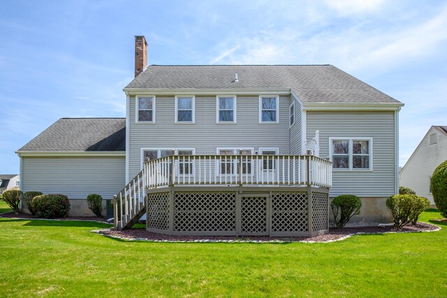 rear view of house featuring a deck, a yard, stairway, and a chimney