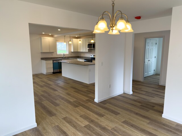 1 First St, Thompson, CT 06255 - kitchen with stainless steel appliances, a sink, dark wood-style floors, dark countertops, and baseboards