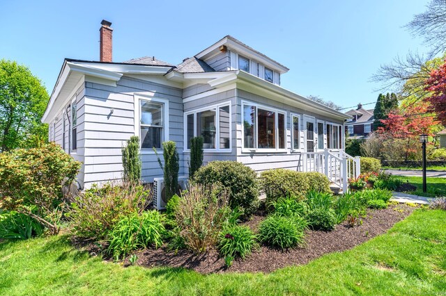view of front of house with central AC and a chimney