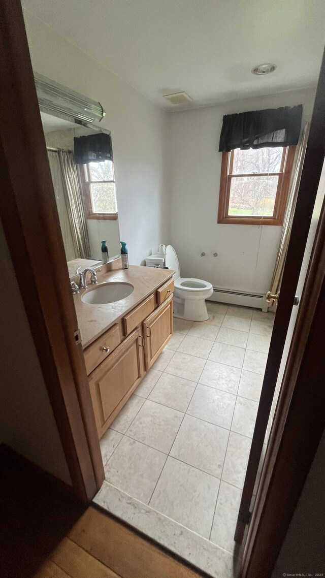 bathroom featuring vanity, a baseboard radiator, toilet, and tile patterned flooring