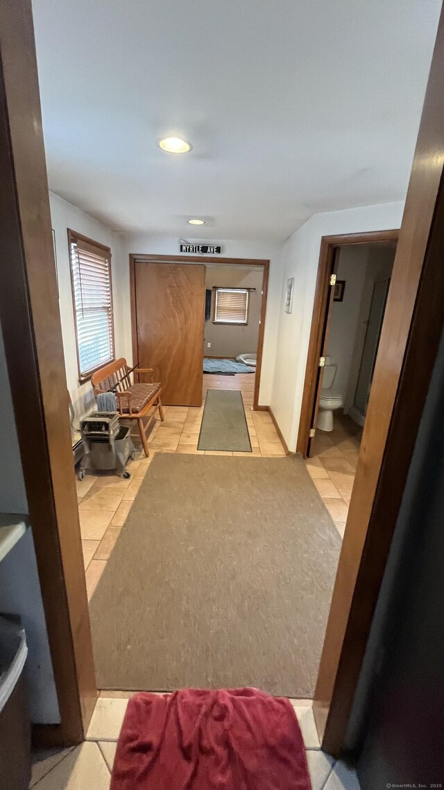 corridor with recessed lighting and light tile patterned floors