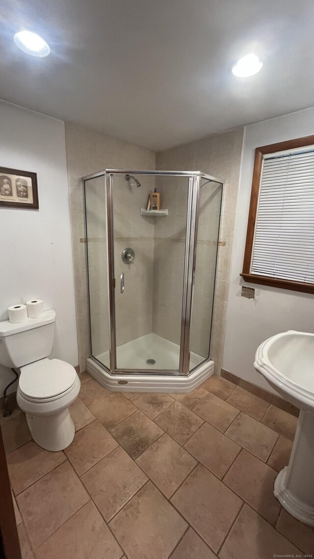 full bath with toilet and a stall shower
