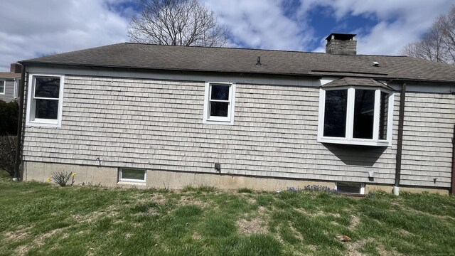 view of side of property featuring a lawn and a chimney