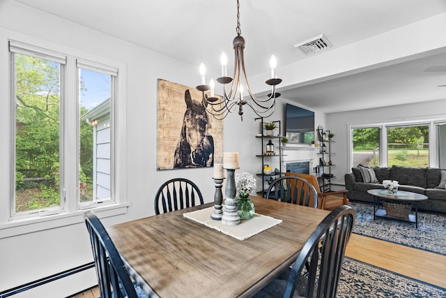 52 Pine Orchard Rd, Branford, CT 06405 - dining space with baseboard heating, a chandelier, wood finished floors, and a fireplace