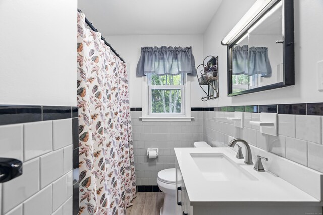 52 Pine Orchard Rd, Branford, CT 06405 - bathroom with tile walls, toilet, vanity, wainscoting, and wood finished floors