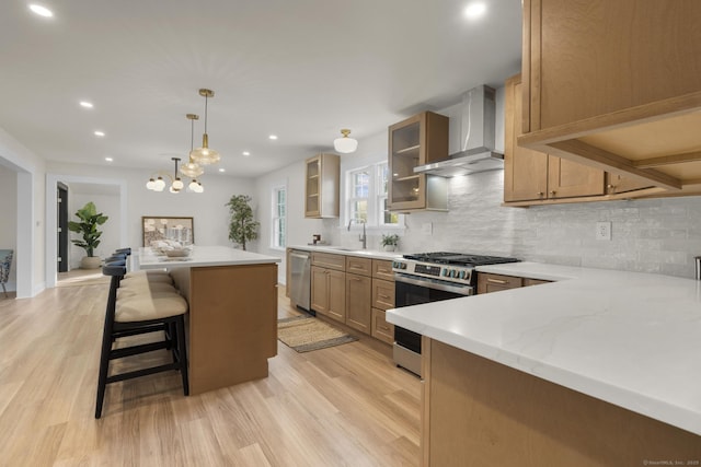 128 Bancroft Ave, Bridgeport, CT 06604 - kitchen featuring wall chimney range hood, appliances with stainless steel finishes, backsplash, light wood-style floors, and recessed lighting
