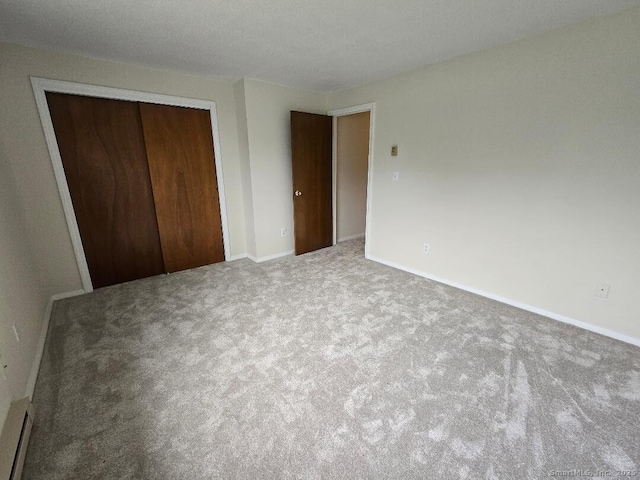 71 Arthur St Apt 2, Torrington, CT 06790 - unfurnished bedroom with a closet, carpet flooring, a baseboard radiator, and baseboards