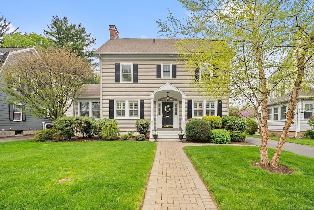 191 Four Mile Rd, West Hartford, CT 06107 - colonial house with a front lawn and a chimney