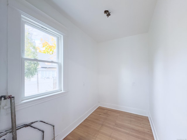 unfurnished room featuring plenty of natural light, baseboards, and light wood-type flooring
