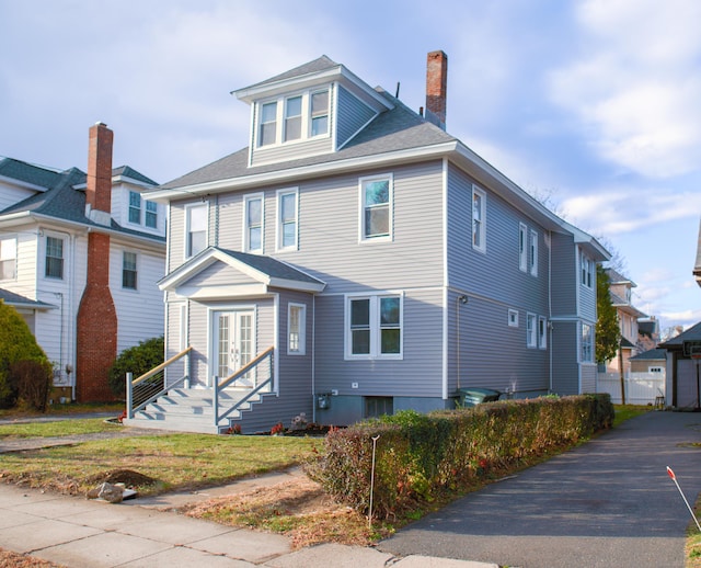 traditional style home featuring a chimney, french doors, and a residential view