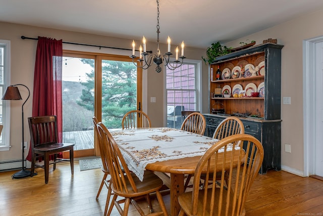 dining space featuring an inviting chandelier and light wood-type flooring