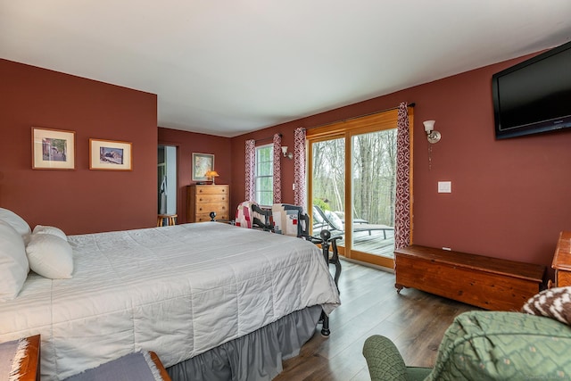 bedroom with access to outside and wood finished floors