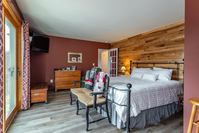 bedroom with wood walls and wood finished floors