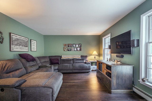 living area with a baseboard heating unit, dark wood-style floors, and plenty of natural light