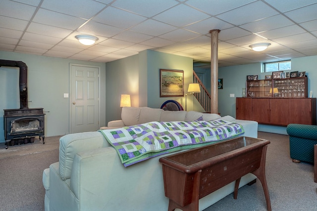 carpeted bedroom featuring a wood stove and a paneled ceiling