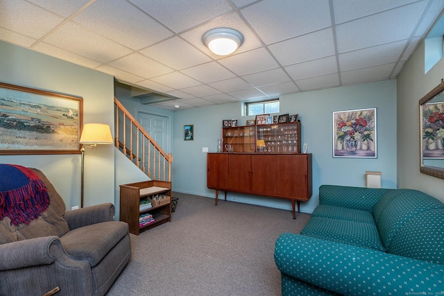 carpeted living room with stairs and a drop ceiling
