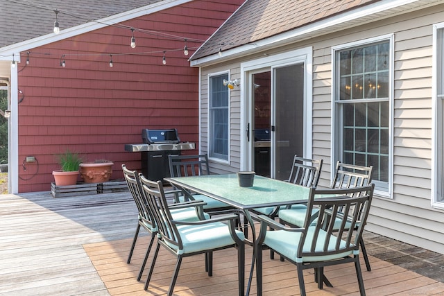 deck featuring outdoor dining space and area for grilling