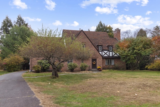 386 Bloomfield Ave, West Hartford, CT 06117 - tudor-style house featuring a chimney, brick siding, and a front yard