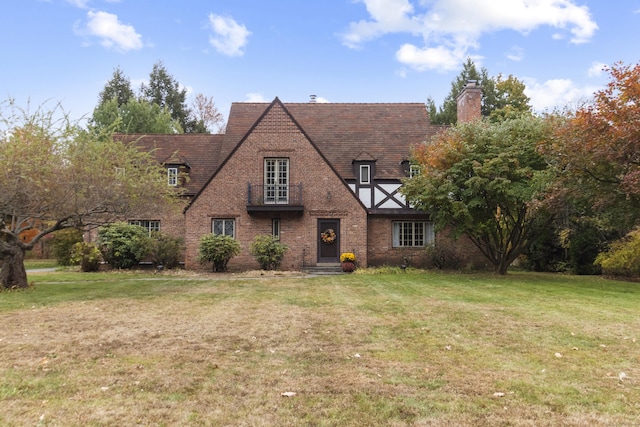 386 Bloomfield Ave, West Hartford, CT 06117 - tudor home featuring a chimney, a front lawn, and brick siding