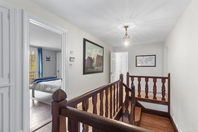 386 Bloomfield Ave, West Hartford, CT 06117 - corridor featuring wood finished floors, baseboards, a notable chandelier, and an upstairs landing