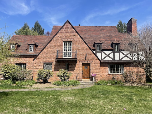 386 Bloomfield Ave, West Hartford, CT 06117 - tudor-style house featuring a front lawn, a chimney, and brick siding