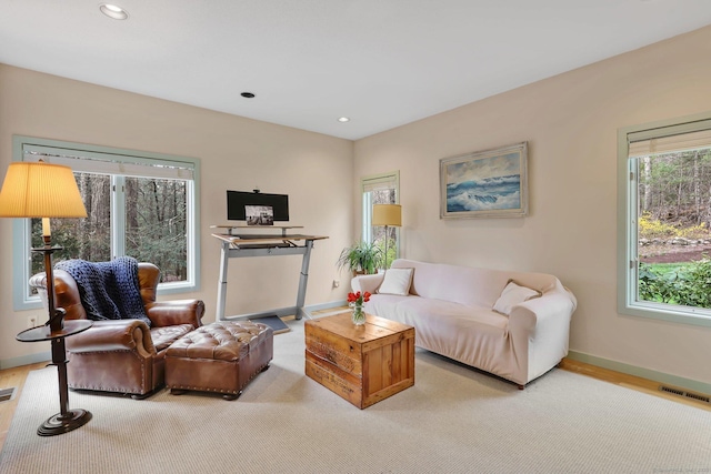 living room with baseboards, visible vents, and a wealth of natural light