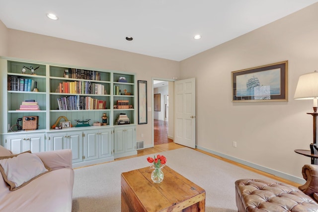 living room with recessed lighting, visible vents, light carpet, and baseboards